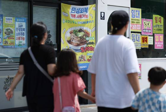 지난 27일 경북 경산시 한 상가에 소비쿠폰 사용처란 안내 현수막이 붙어 있다. 연합뉴스