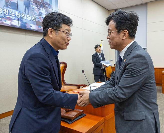 국회 환경노동위원회 안호영 위원장(왼쪽)과 김영훈 고용노동부 장관이 28일 윤석열 전 대통령이 거부권(재의요구권)을 행사했던 '노란봉투법'(노조법 2·3조 개정안)이 국회 환경노동위원회에서 통과된 뒤 악수하고 있다. 이날 노조법  2·3조 개정안은 이날 소위를 통과한 뒤 환노위 전체회의에서 국민의힘 의원들이 퇴장한 가운데 처리됐다./사진=연합뉴스
