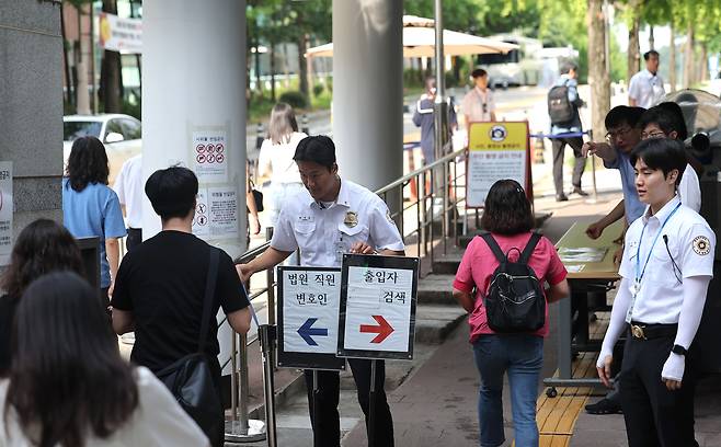 지난 24일 윤석열 전 대통령의 내란 우두머리 혐의 관련 재판 12차 공판 기일이 열리는 서울 서초구 서울중앙지방법원 입구에 법원 보안 인력이 배치되어 있다. 윤 전 대통령은 이날 재판부에 건강상의 사유로 출석하기 어렵다는 내용의 의견서를 제출하며 재판에 불출석했다. 사진공동취재단