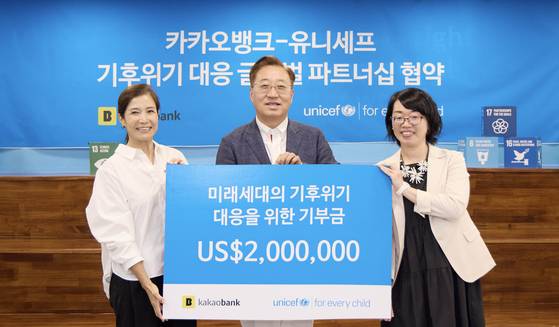 Kakao Bank CEO Yun Ho-young, center, poses for a commemorative photo with Kanetaka Sawako, right, lead of Unicef’s Asia-Pacific hub, and Cho Mi-jin, secretary general of the Korean Committee for Unicef, after signing a global partnership agreement on climate crisis response for future generations at the Unicef Korea office on July 28. [KAKAO BANK]