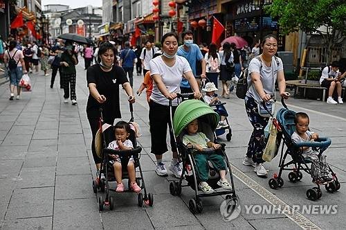 유모차 끌고 가는 중국 베이징의 시민들. [AFP 연합뉴스]