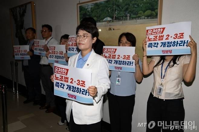 (서울=뉴스1) 유승관 기자 = 전종덕 진보당 의원이 28일 서울 여의도 국회 환경노동위원회 소회의실 앞에서 고용노동법안심사소위원회에 참석하는 의원들을 향해 노조법 개정을 촉구하는 손팻말을 들고 있다.  환노위는 이날 소위를 열고 노동조합 및 노동관계조정법 일부개정법률안(노란봉투법)을 심사한다. 2025.7.28/뉴스1  Copyright (C) 뉴스1. All rights reserved. 무단 전재 및 재배포,  AI학습 이용 금지. /사진=(서울=뉴스1) 유승관 기자