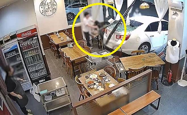 지난 11일 오후 인천 서구 청라동의 한 중식당 통유리를 깨고 승용차가 돌진하자 식사 중이던 커플이 황급히 대피하는 모습. 연합뉴스