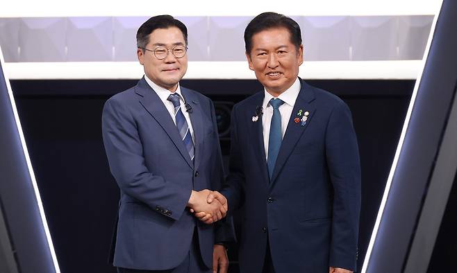박찬대(왼쪽), 정청래 더불어민주당 당대표 후보가 27일 서울 여의도 KBS 신관 공개홀에서 TV토론회 시작 전 악수를 하며 포즈를 취하고 있다. 뉴스1