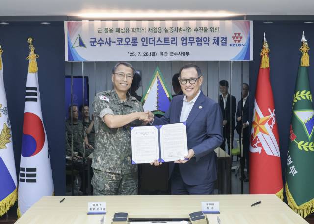 허성(오른쪽) 코오롱인더스트리 대표이사와 손대권 육군군수사령부 사령관이 28일 군 불용물자 자원순환 시범사업을 위한 업무협약(MOU)을 체결한 후 기념 촬영을 하고 있다. 사진 제공=코오롱인더스트리