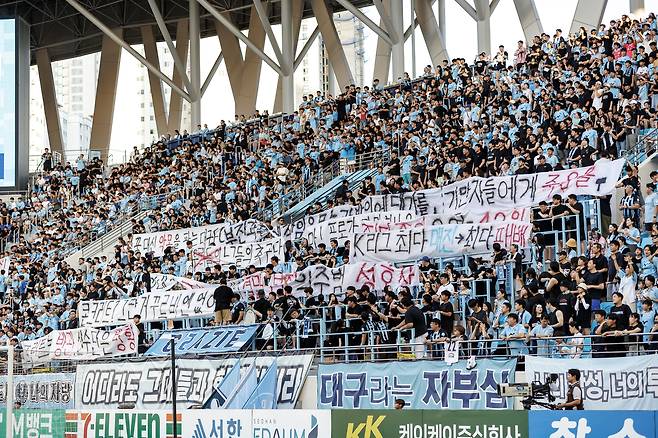 대구FC 서포터들이 27일 포항 스틸러스와의 홈 경기에 앞서 구단 운영을 비판하는 문구가 담긴 걸개를 들고 서 있다. 프로축구연맹 제공