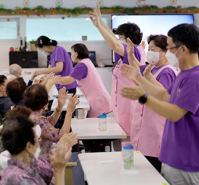 ▲&nbsp;요양보호사의 처우 개선 방안이 지속적으로 거론되고 있는 가운데 2023년 8월 수원시 권선구 금곡동에 위치한 주간보호시설인에서 요양보호사들이 어르신들 식사시간에 앞서 율동을 같이 하고 있다. /김철빈 기자 narodo@incheonilbo.com