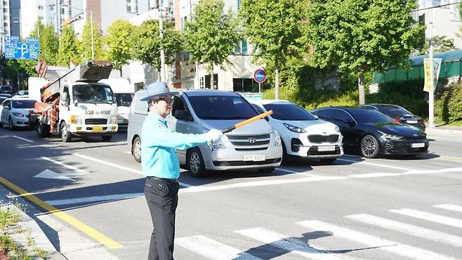 30일 오전 8시30분께 광주 남구 용산IC 방향 용대로 사거리에서 남부모범운전자회 박기업씨가 횡단보도를 건너는 시민을 위해 경광봉을 들고 교통정리를 하고 있다./주성학 기자