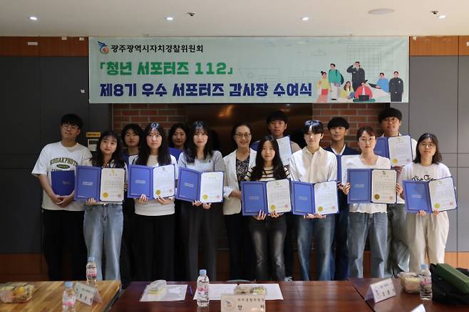 안진 광주시자치경찰위원회 위원장이 30일 '청년서포터즈 112' 제8기 우수 서포터즈에게 감사장을 수여한 뒤 기념사진을 찍고 있다./광주시자치경찰위 제공 .