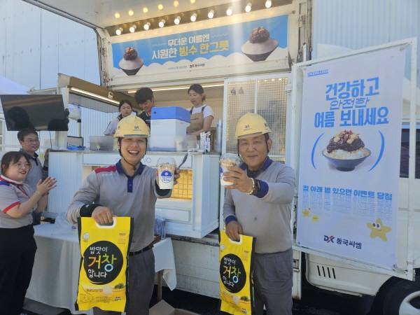 동국씨엠 부산공장 근로자들이 회사측에서 마련한 아이스데이를 통해 제공한 얼음음료와 쌀선물을 들고 즐거워하는 모습