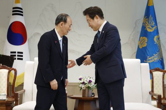 이재명 대통령이 30일 서울 용산 대통령실 청사에서 일한의원연맹 회장인 스가 요시히데 전 일본 총리를 접견하며 자리를 권하고 있다. 연합뉴스