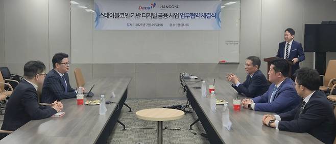 진창용 다날 사업부문 대표(좌측 안쪽)와 송상엽 한컴위드 대표(우측 안쪽)가 업무협약을 체결하는 모습