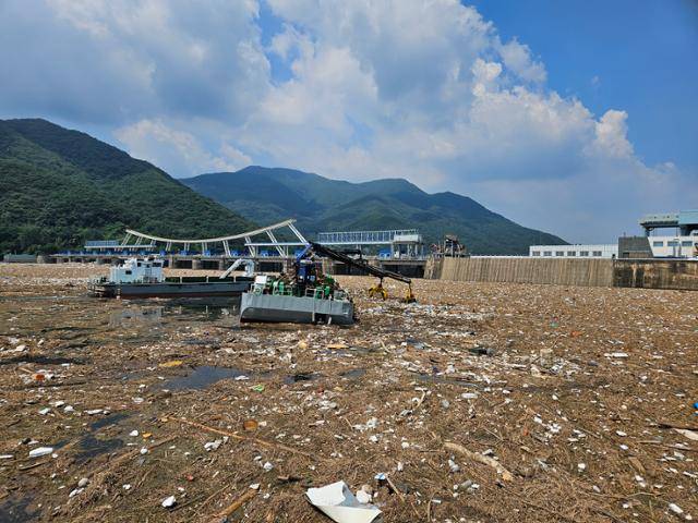 소방당국이 지난 28일 팔당댐 주변에 집적된 각종 부유물(쓰레기, 나뭇가지 등) 내 실종자 흔적 여부 확인 인명 수색과 동시에 환경 정화 작업 병행하고 있다. 경기북부소방재난본부 제공