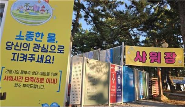 ▲ 강원 동해안 대표 해수욕장인 강릉 경포해수욕장 유료 샤워장에 설치된 '샤워 시간 단축 협조 요청 안내문' [연합뉴스]