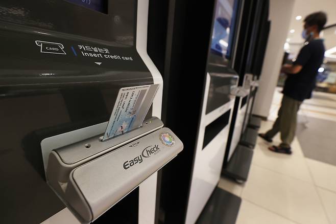 A person pays with a credit card at a self-service kiosk in Seoul on July 26, 2022. [YONHAP]
