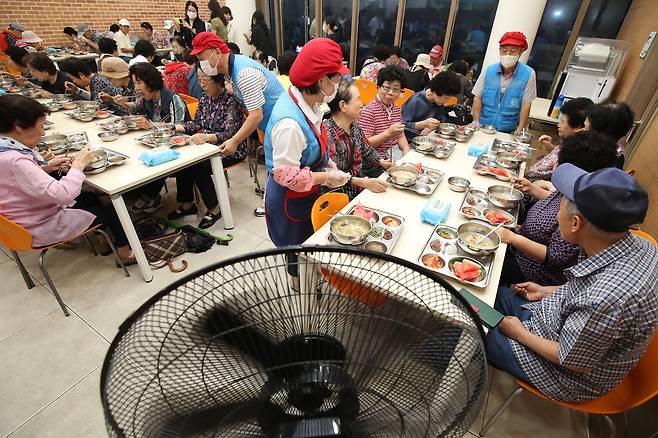 Volunteers serve samgyetang (chicken ginseng soup) and watermelon to older people at a social welfare center in Daemyeong-dong, Nam District, Daegu, on July 17. [NEWS1]