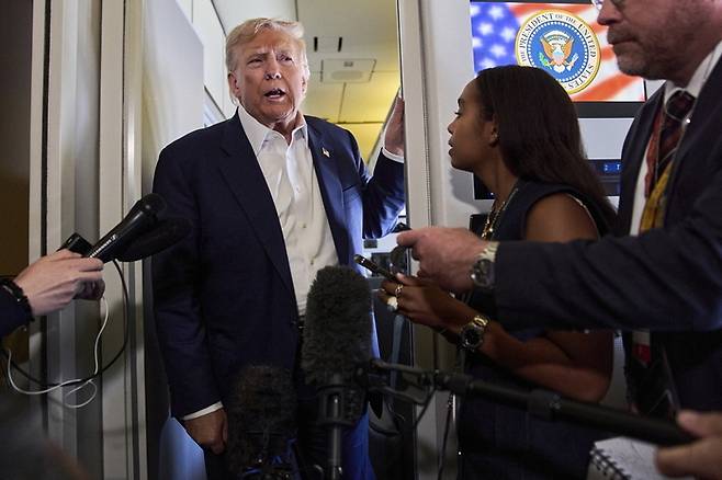 미국과 중국 고위 협상단이 ‘관세 휴전’ 90일 연장안에 잠정 합의한 29일(현지시간) 도널드 트럼프 미국 대통령이 스코틀랜드 방문을 마치고 전용기 안에서 기자들에게 관련 내용을 얘기하고 있다. [AP = 연합뉴스]