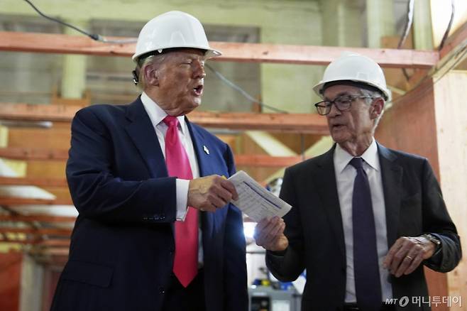 도널드 트럼프 미국 대통령(왼쪽)이 지난 24일(현지시간) 워싱턴 DC 연방준비제도(연준) 건물 개보수 현장을 방문해 제롬 파월 연준 의장에게 비용 관련 문서를 건네고 있다. /AP=뉴시스