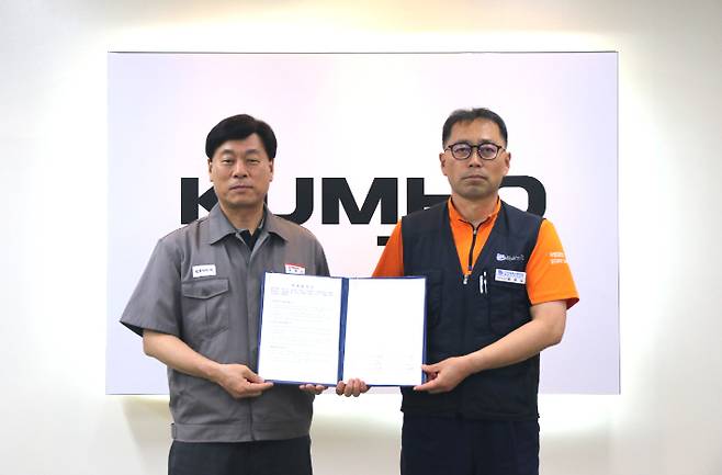 김명선 금호타이어 생산기술총괄 부사장(사진 왼쪽)과 황용필 금호타이어지회 대표 지회장이 노사 특별합의문을 들고 사진을 찍고 있다. 금호타이어 제공