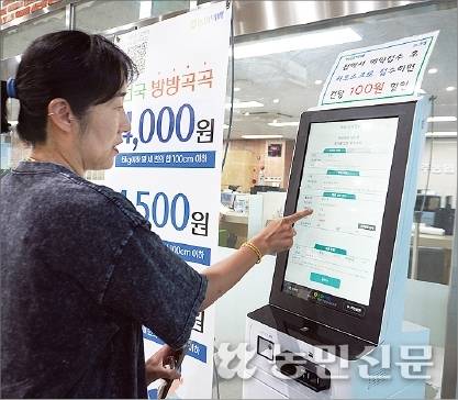 경기 파주에서 콩농사를 짓는 김지현씨가 북파주농협 자재센터에서 키오스크(터치스크린 방식의 무인단말기)를 통해 개인택배 서비스를 신청하고 있다.