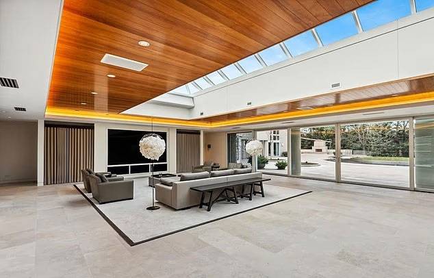 조던 저택의 메인 거실 전경 - 천창으로 자연광이 들어오는 넓은 거실. 대형 TV와 현대적인 소파 세트가 배치돼 있으며, 통유리 창 너머로 안뜰이 한눈에 들어온다. 출처=챔피언스 포인트