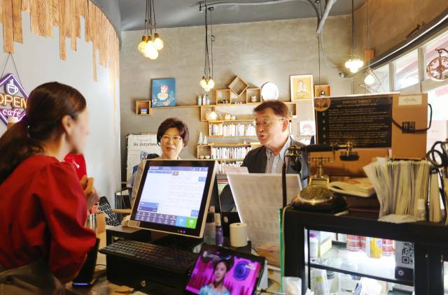 박성효(오른쪽 첫 번째) 소상공인시장진흥공단 이사장이 29일 대전에 있는 한 카페를 찾아 소상공인 부담경감 크레딧 지원사업에 대한 의견을 듣고 있다. 사진 제공=소진공