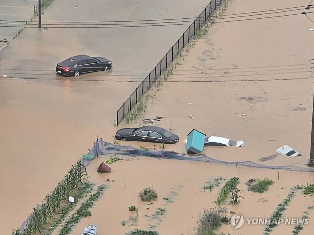 극한 호우가 쏟아진 17일 오후 광주 북구 신용동 일대 도로가 침수돼 차량들이 물에 잠겨 있다. 연합뉴스.