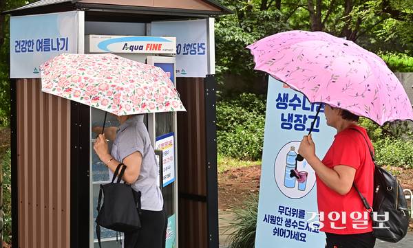 연일 폭염이 지속되고 있는 31일 오후 인천시 미추홀구 관교동에 설치된 생수나눔냉장고를 찾은 시민이 물을 꺼내고 있다. 2025.7.31 /조재현기자 jhc@kyeongin.com