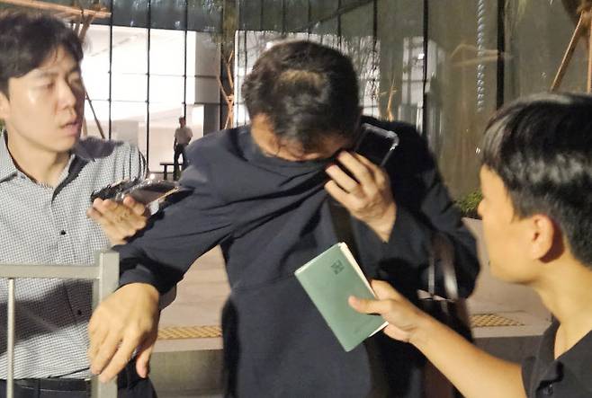 김건희 여사 오빠인 김진우 씨가 지난 28일 김 여사 관련 의혹들을 수사하는 민중기 특별검사팀 사무실이 위치한 서울 종로구 KT광화문빌딩에서 조사를 마친 뒤 얼굴을 가린 채 특검 사무실을 나서고 있다. 김씨는 이른바 ‘양평 공흥지구 개발 특혜 의혹’의 핵심 당사자다. (사진=연합뉴스)