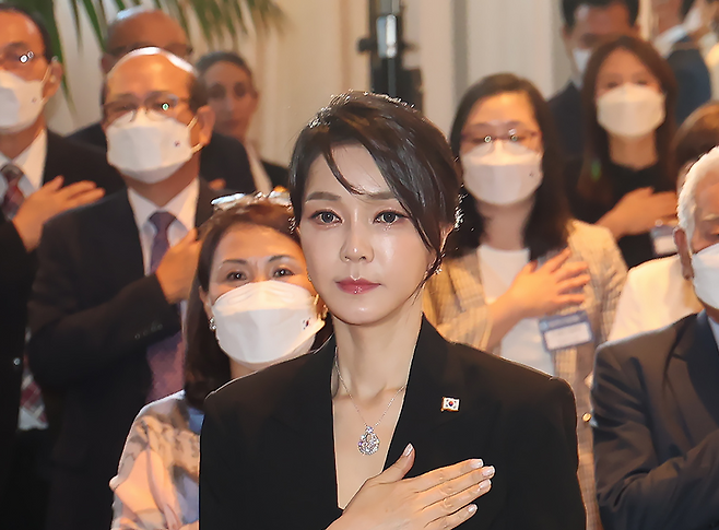 2022년 6월29일(현지시간) 스페인 마드리드 만다린 오리엔탈 리츠호텔에서 열린 동포 만찬간담회에서 전직 대통령 윤석열의 부인 김건희가 국민의례를 하고 있다. 목에는 반클리프 목걸이를 착용하고 있다. 연합뉴스