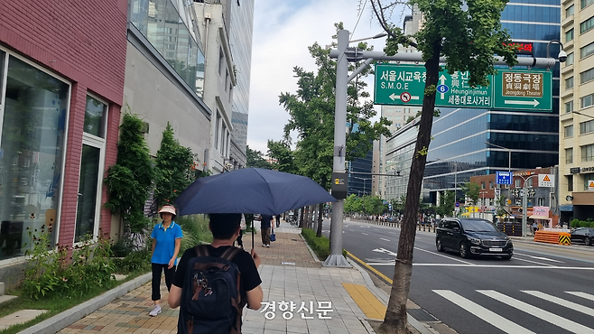 강방식씨(55)가 지난 30일 양산을 쓰고 나무 그늘이 없는 서울 종로구 새문안로를 걷고 있다. 강한들 기자