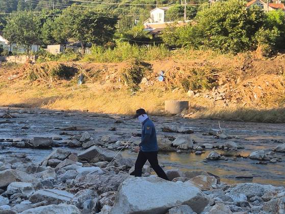 An official from the Gyeonggi Northern Police Agency searches for a missing person in the Jojongcheon Valley in Deokhyeon-ri, Gapyeong, Gyeonggi on July 27. [OH SO-YEONG]