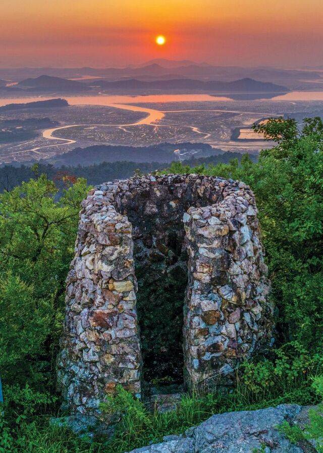 전남 무안군 삼향면 봉수산 정상 봉수대 너머로 물 빠진 서해 갯벌과 물길이 저녁노을에 붉게 물들어 있다.