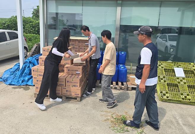 사단법인 대한한돈협회 서산태안지부가 고온 스트레스 완화제를 농가에 공급하는 모습. 서산시 제공