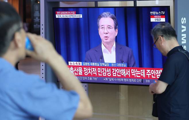 미국과 관세 협상이 15%로 타결된 31일 오전 서울 용산구 서울역에서 시민들이 김용범 정책실장의 미국과 관세 협상 타결 관련 브리핑을 시청하고 있다. 뉴시스