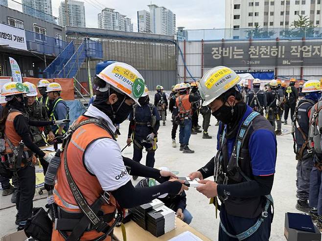 보건관리자의 근로자 물 보급 및 작업 전 토시 보급 사진. (사진=DL건설)