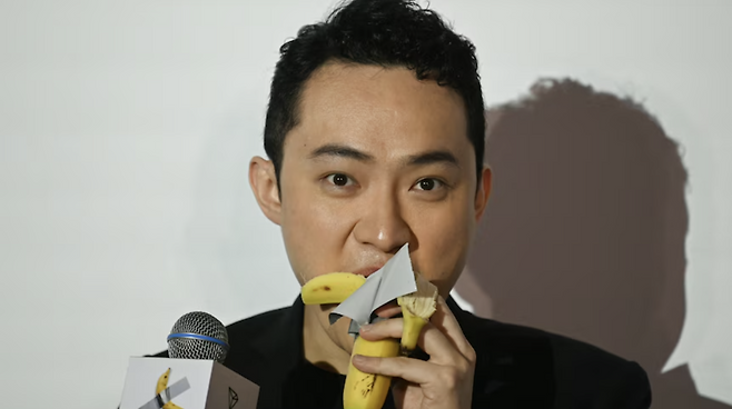 지난해 11월 마우리치오 카텔란 작품 ‘코미디언’을 86억7000만원에 낙찰받은 30대 홍콩 암호화폐 사업가인 저스틴 선이 작품의 바나나를 떼어내 먹는 모습. [APF/연합]