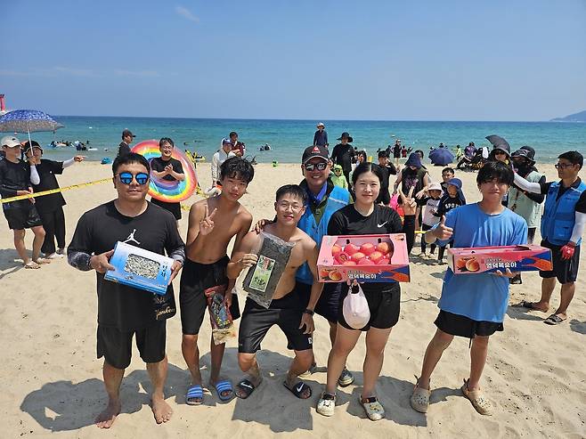 관광객들이‘보물 백합’을 찾아 환하게 웃고 있다. 백합 조개 속 리본 표시를 찾으면 지역 특산물로 교환할 수 있다.