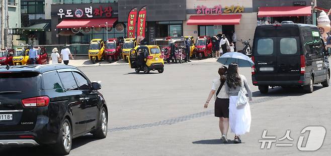 지난 1일 오전 우도 하우목동항 앞 교차로가 차량과 보행자, 이륜차로 혼잡한 모습을 보이고 있다.