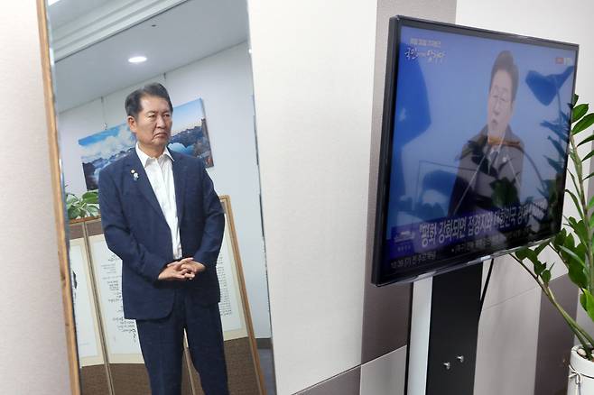 더불어민주당 당대표 후보인 정청래 의원이 지난 7월 3일 서울 여의도 국회 의원회관 사무실에서 이재명 대통령의 취임30일 기자회견을 TV를 통해 지켜보며 오송참사 간담회 참석자들을 기다리고 있다. 의원실에 세워둔 거울에 비친 모습. /연합뉴스