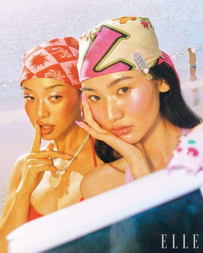 요요의 레드 비키니는 Kupido. 커버 업은 Finca. 헤어 반다나로 활용한 스카프는 Daze Dayz. 목걸이는 Abitmor. 민주의 원피스 수영복은 Kupido. 헤어에 두른 스카프는 Zara. 헤어핀은 Eireve. 토끼 비즈 네크리스는 Uvula. 실버 링은 Leclat. 요요와 민주가 착용한 비즈 팔찌는 모두 스타일리스트 소장품.