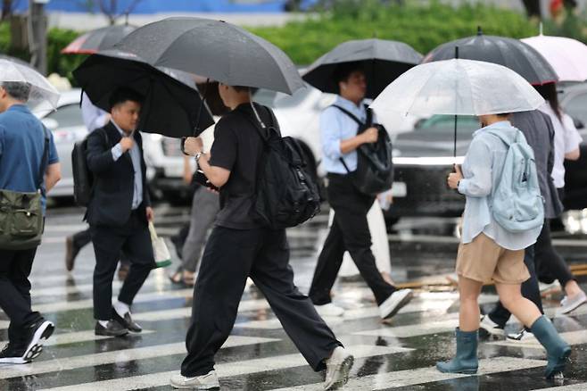 지난 6 20일 오전 서울 광화문네거리에서 우산을 쓴 시민들이 출근하고 있다. 뉴스1