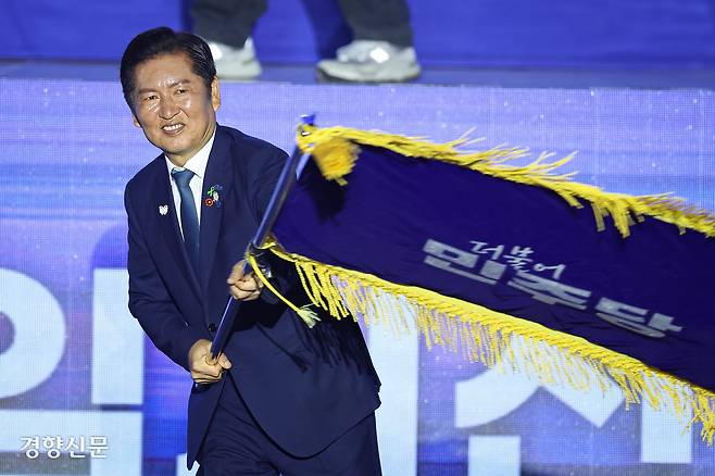 정청래 신임 더불어민주당 대표가 2일 경기 고양시 킨텍스에서 열린 임시전국당원대회에서 당대표로 선출된 뒤 무대에 올라 당기를 흔들고 있다. 박민규 선임기자