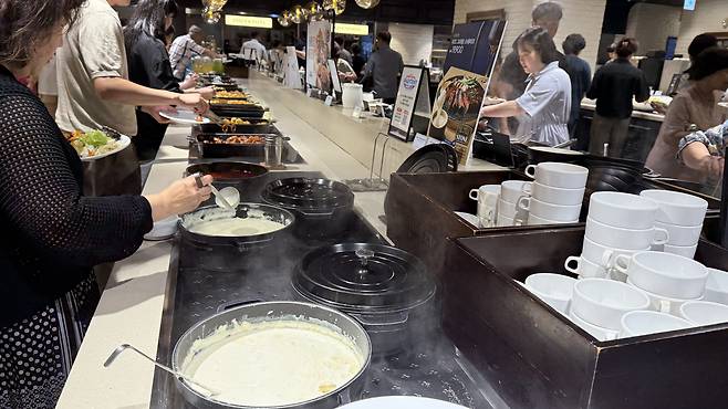 Customers grab food from the buffet at Ashley Queens in Songpa District, southern Seoul, on July 24.[WOO JI-WON]