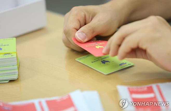 민생회복 소비쿠폰 색상 교체 (광주=연합뉴스) 김혜인 기자 = 24일 광주 북구 한 행정복지센터에서 공무원들이 소비쿠폰 현물카드에 스티커를 붙여 색상을 교체하고 있다.
    광주시는 소득수준별 소비쿠폰 현물 카드 색상을 달리해 인권 감수성이 부족하다는 지탄을 받았다. 2025.7.24 in@yna.co.kr