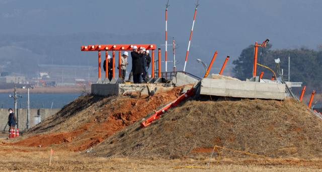 26일 오후 전남 무안국제공항에서 항공철도사고조사위원회, 경찰, 국과수 관계자들과 제주항공 참사 유가족 대표단이 방위각 시설(로컬라이저)을 살펴보고 있다. 연합뉴스