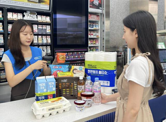GS25에서 고객이 8월 행사 상품을 구매하고 있는 연출 이미지. (제공=GS리테일)