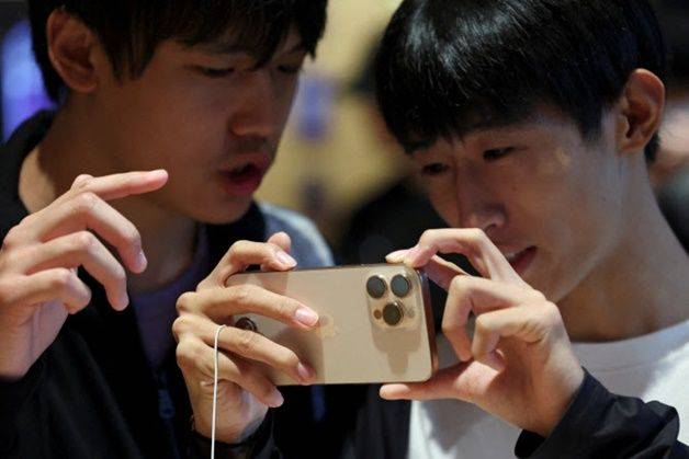 지난해 9월20일 중국 베이징의 한 애플 스토어에서 시민들이 새로운 아이폰 16 시리즈 스마트폰이 판매되는 동안 아이폰 16 프로를 살펴보고 있다. ⓒ 로이터/연합뉴스