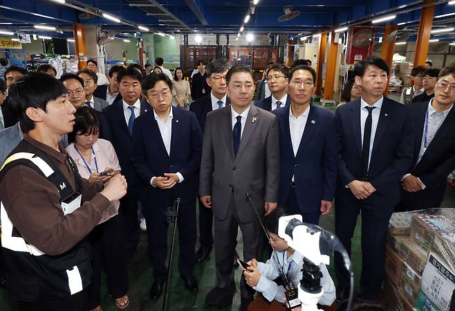 김병기 더불어민주당 대표 직무대행 겸 원내대표(가운데)가 지난 7월 16일 서울 서초구 쿠팡로지스틱스서비스(CLS) 서브허브를 방문해 작업장을 둘러보고 있다. 연합뉴스