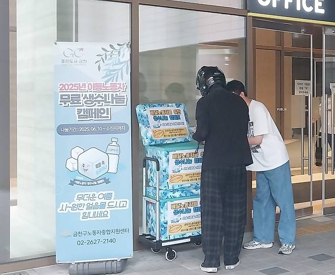 한 이동노동자가 지난 1일 ‘2025년 이동노동자 생수나눔 캠페인’의  일환으로 비치된 생수를 꺼내 가고 있다.